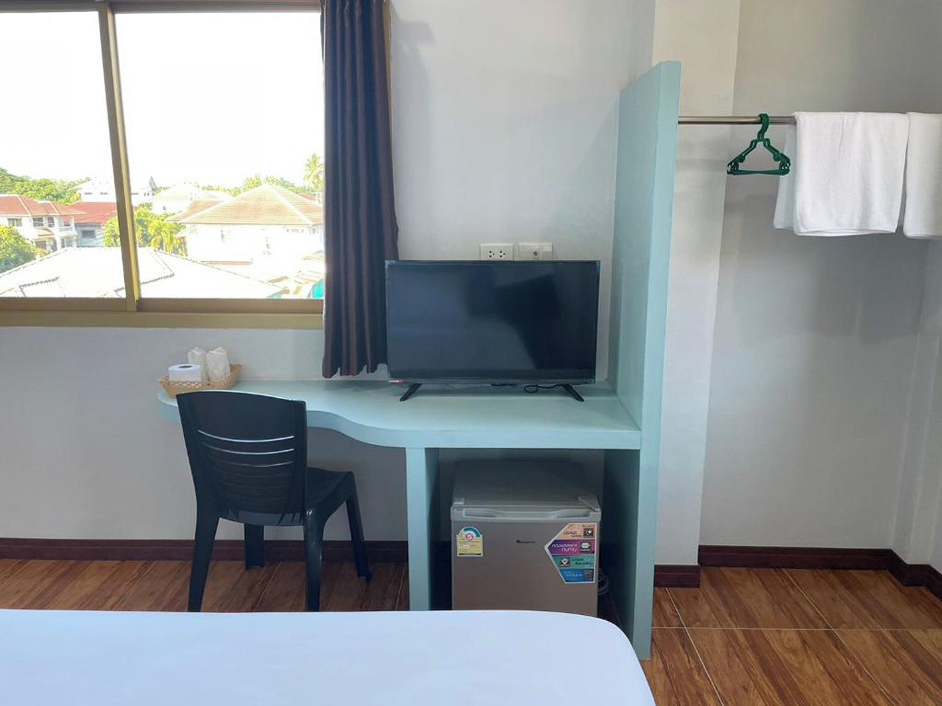 Une chambre d’hôtel équipée d’un bureau, d’une chaise et d’un petit réfrigérateur.