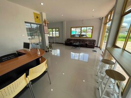 Un salón amplio con sofá, mesa de comedor con sillas y un gran ventanal con vistas al exterior.