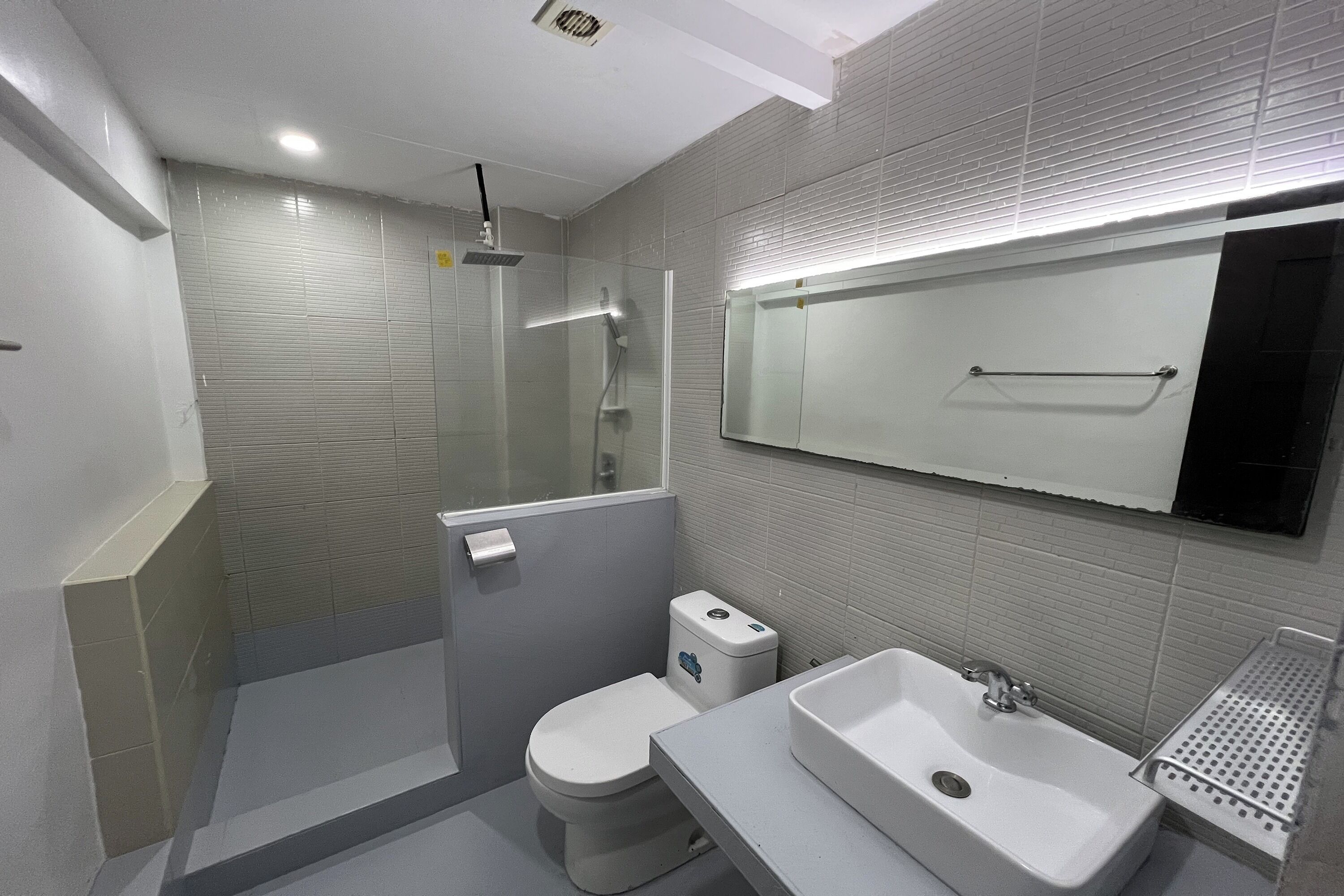 Un baño moderno con ducha, inodoro y dos lavamanos.