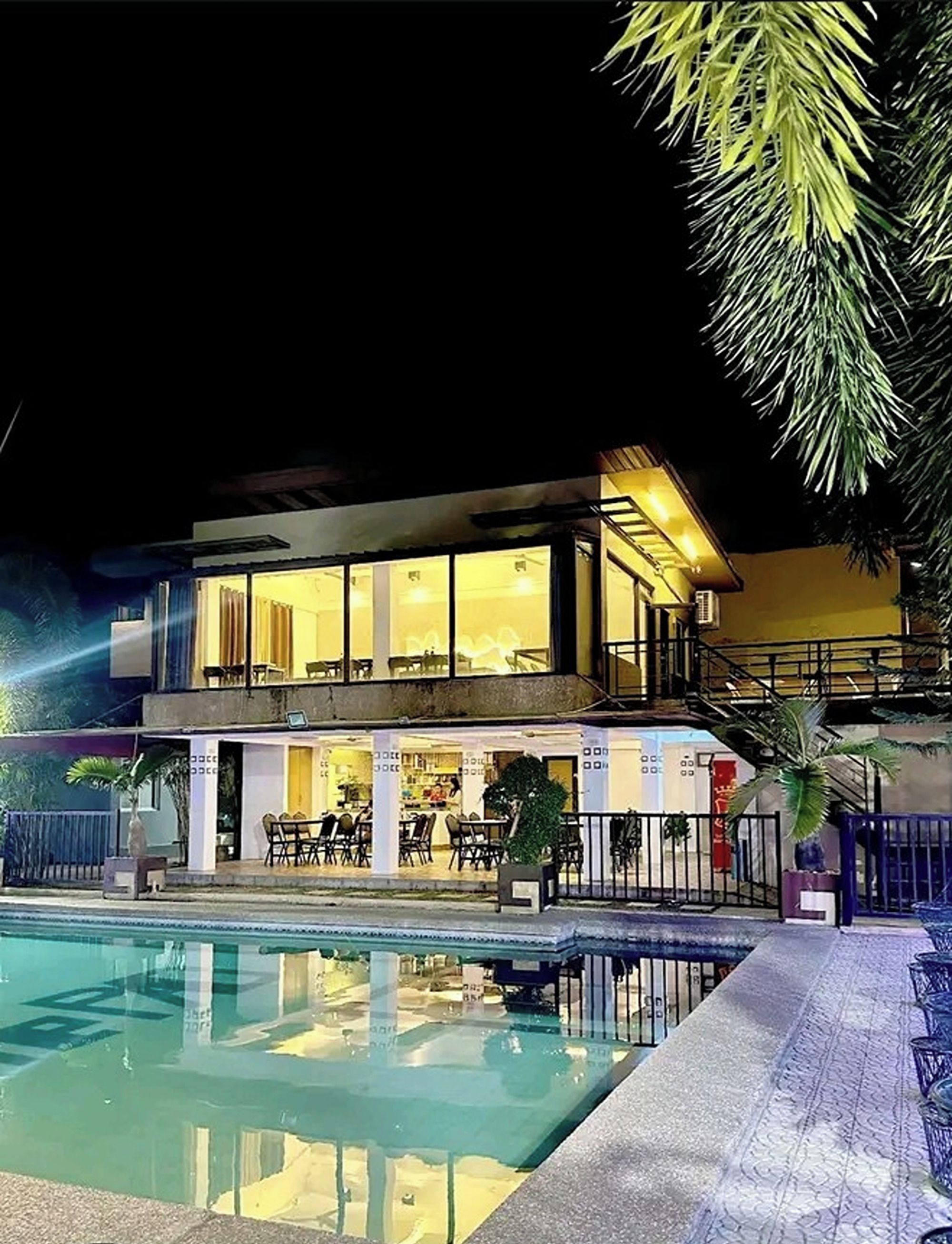 A two-story building with a pool in the foreground.