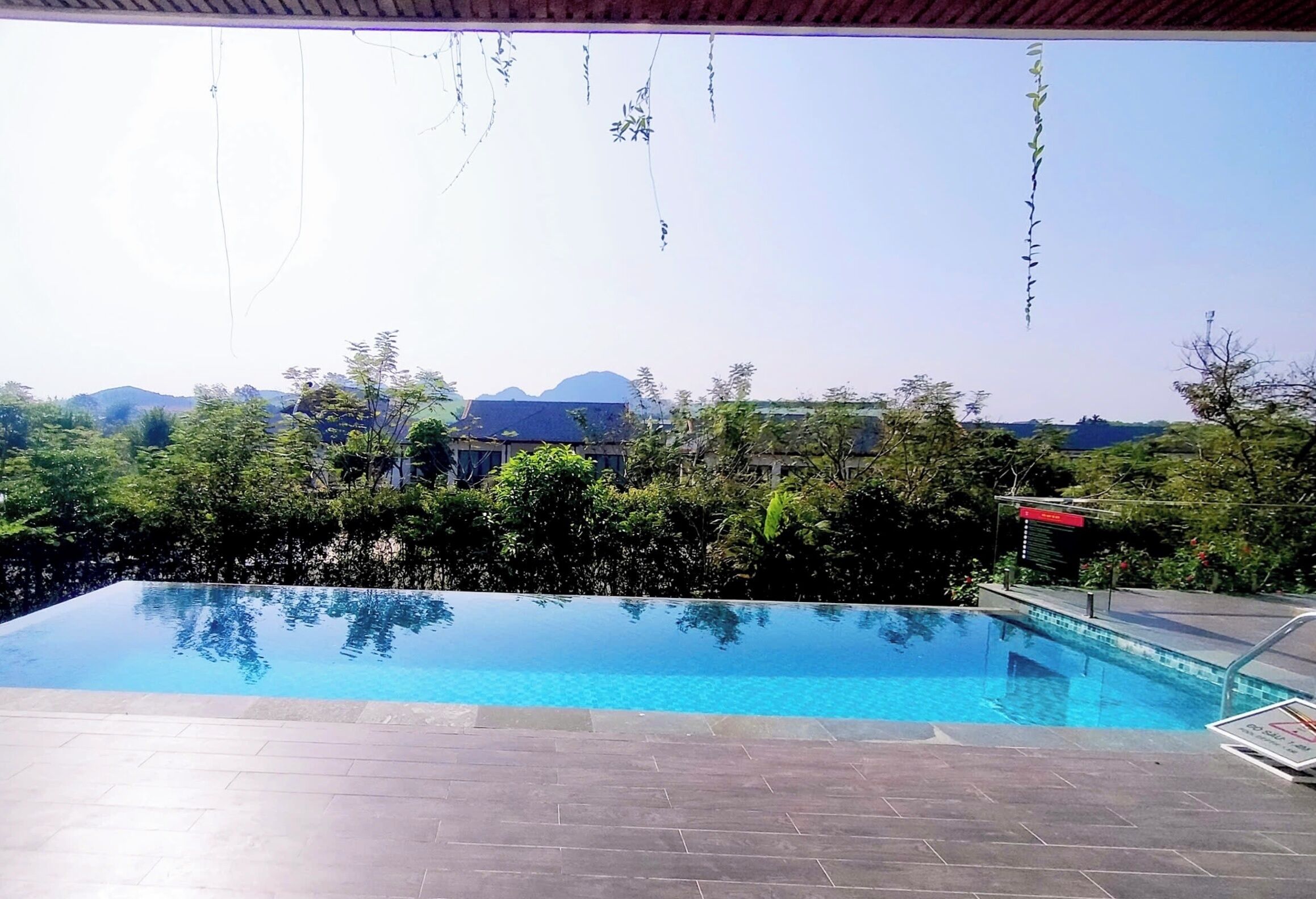 A swimming pool with a view of hills and trees.