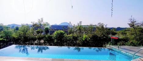 A swimming pool with a view of hills and trees.