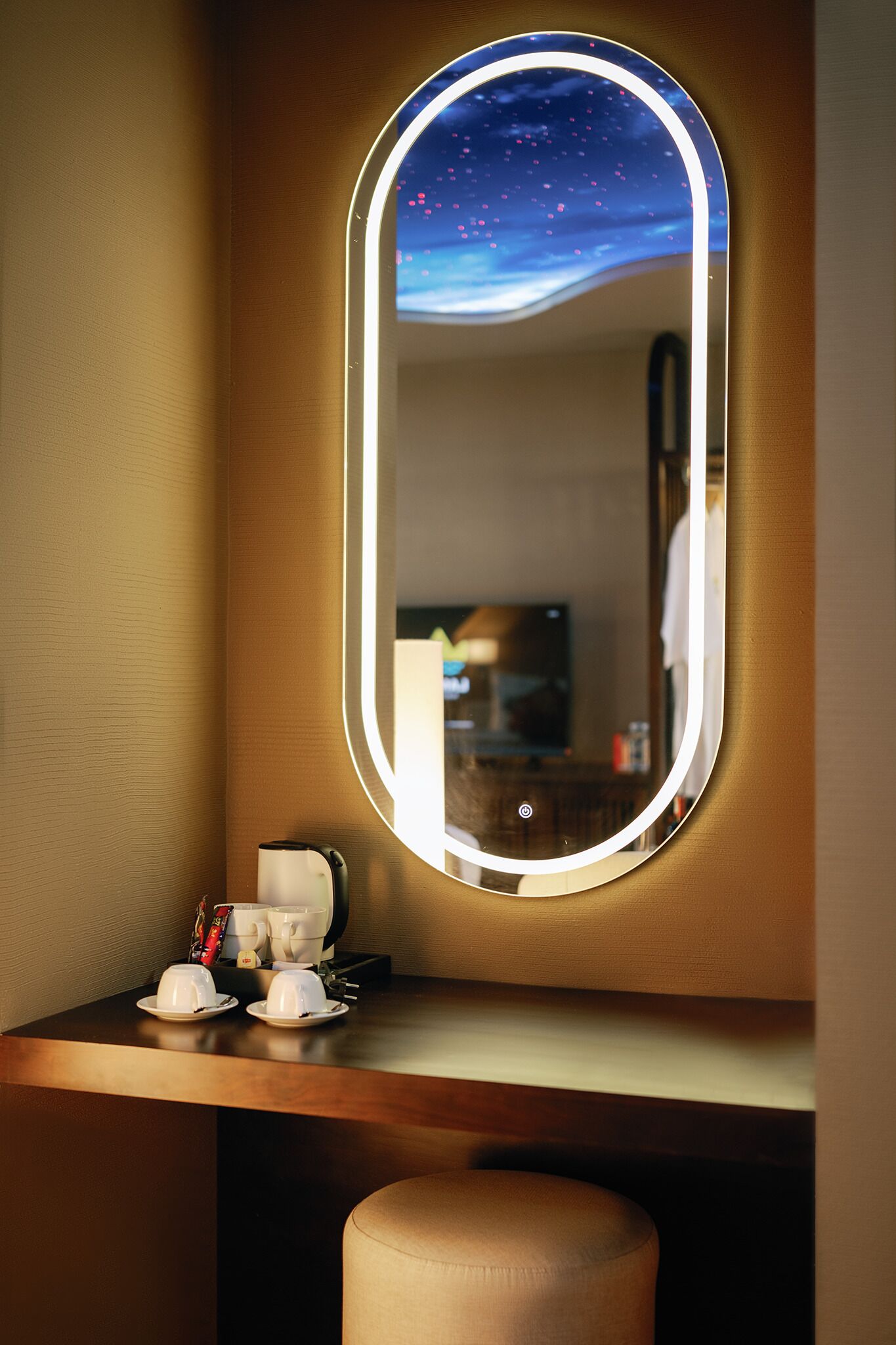 A bathroom vanity with a mirror, a cup holder, and a towel.