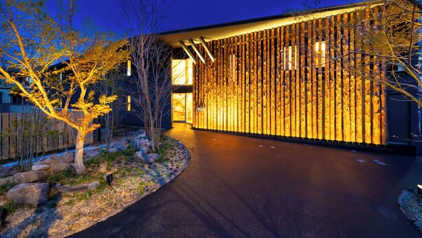 A modern building with a wooden facade and a pathway leading to the entrance. - HOTEL DO-YA BEPPU (Beppu)