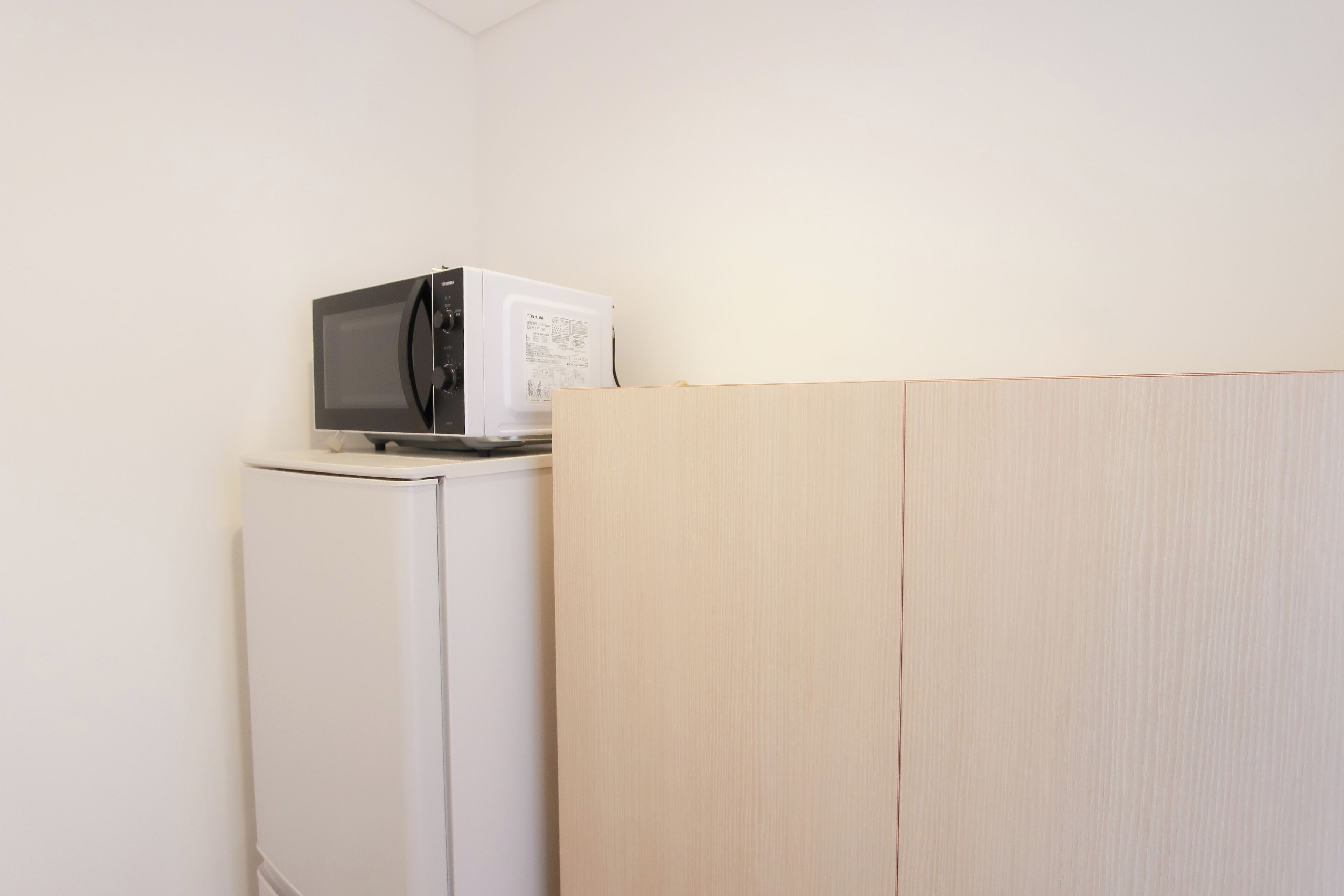 Una kitchenette compacta con microondas y refrigerador.