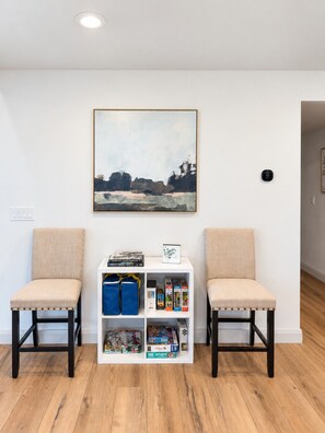 A room with two chairs, a bookshelf with books and games, and a painting on the wall. - Timberhaven - Bear Lake Retreat - Sleeps 50+ (Fish Haven)