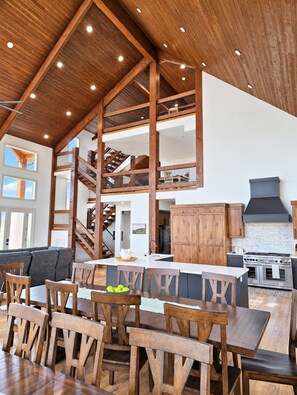 Una cocina amplia con una isla grande, vigas de madera y vistas al nivel superior.