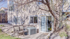 A house with a patio area, outdoor furniture, and a large air conditioning unit. - Charming 1-bdrm walkout basement suite with AC, WiFi in lovely Colorado Springs (Colorado Springs)