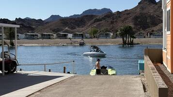 Un port de plaisance avec des bateaux, un jet ski et une personne en maillot de bain.