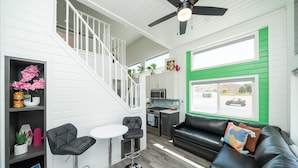 A modern interior with a staircase, kitchen, and seating area. - Blue Bliss, Private Hot Tub & Fenced Yard at Roadrunner Resort (Parker)