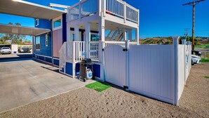 A two-story building with a covered parking area, a gated entrance, and a visible number '20' on the building. - Blue Bliss, Private Hot Tub & Fenced Yard at Roadrunner Resort (Parker)
