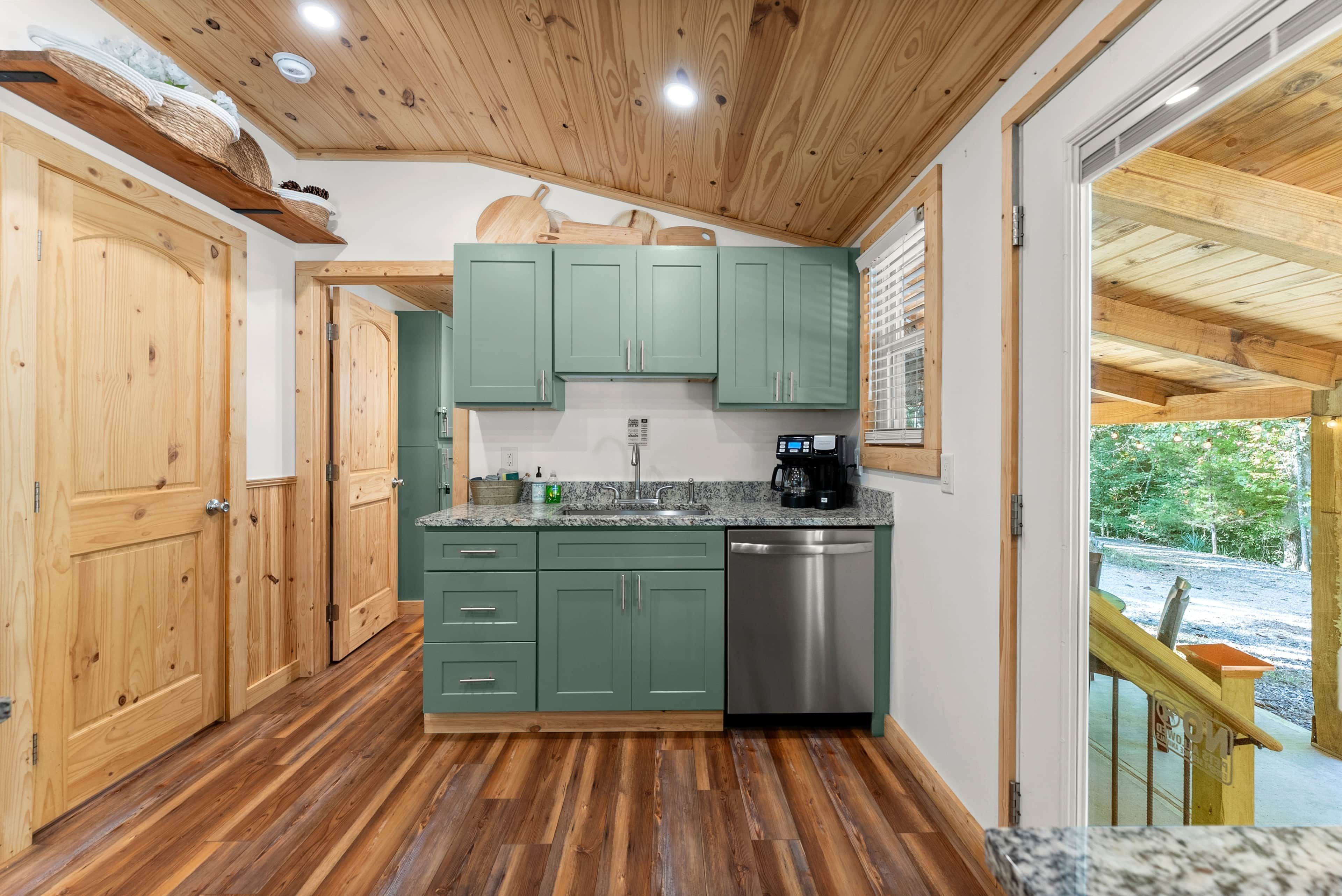 A kitchen with wooden cabinets, a stainless steel dishwasher, and a granite countertop.