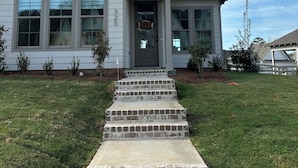 A two-story house with a front porch, a driveway, and a well-maintained lawn. - Charming & Spacious Townhome on North College Street in Auburn (Auburn)