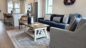 A modern kitchen with white cabinets, a stainless steel refrigerator, and pendant lighting. - Charming & Spacious Townhome on North College Street in Auburn (Auburn)