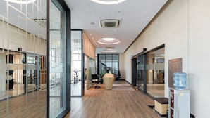 A modern office space with glass partitions, a wooden floor, and a water dispenser. - Luxury D1 Mension Condotel (Ho Chi Minh City)