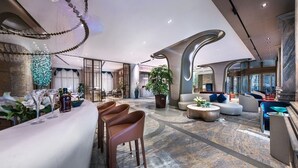 A spacious lobby with a bar area, seating arrangements, and a large potted plant. - Elegant International Hotel Shanghai - Bund Sichuan Road North Metro Station Branch (Shanghai)