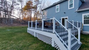 A blue house with a white deck and stairs.