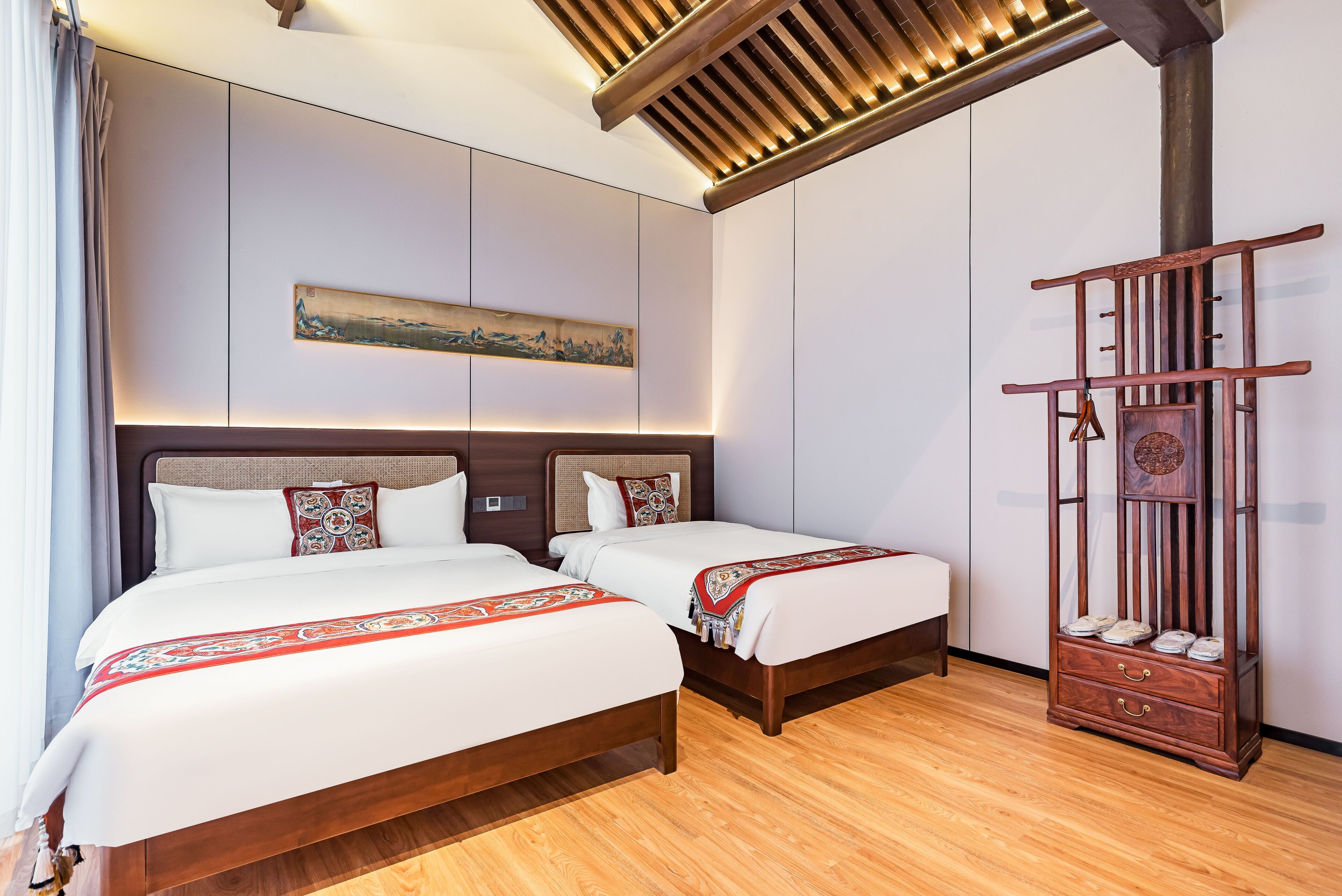 Habitación de hotel con dos camas, un aparador de madera y un techo con diseño de listones.