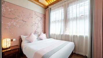A bedroom with a bed, nightstand, and wall art.