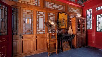 A traditional room with wooden furniture, a red door, and a decorative wall panel.