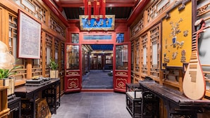 Un cortile tradizionale cinese con architettura in legno, uno spazio aperto centrale e un pavimento piastrellato.
