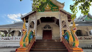 A temple with ornate architecture, a central doorway, and a staircase leading up to it.