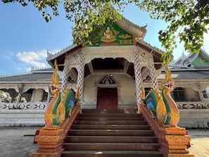 A temple with ornate architecture, a central doorway, and a staircase leading up to it. - Jinghong Chen Duo Nan Shan Man Zhen (Xishuangbanna Dai)
