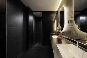 A modern bathroom with a large mirror, a white sink, and a vase with flowers. - Jinghong Chen Duo Nan Shan Man Zhen (Xishuangbanna Dai)