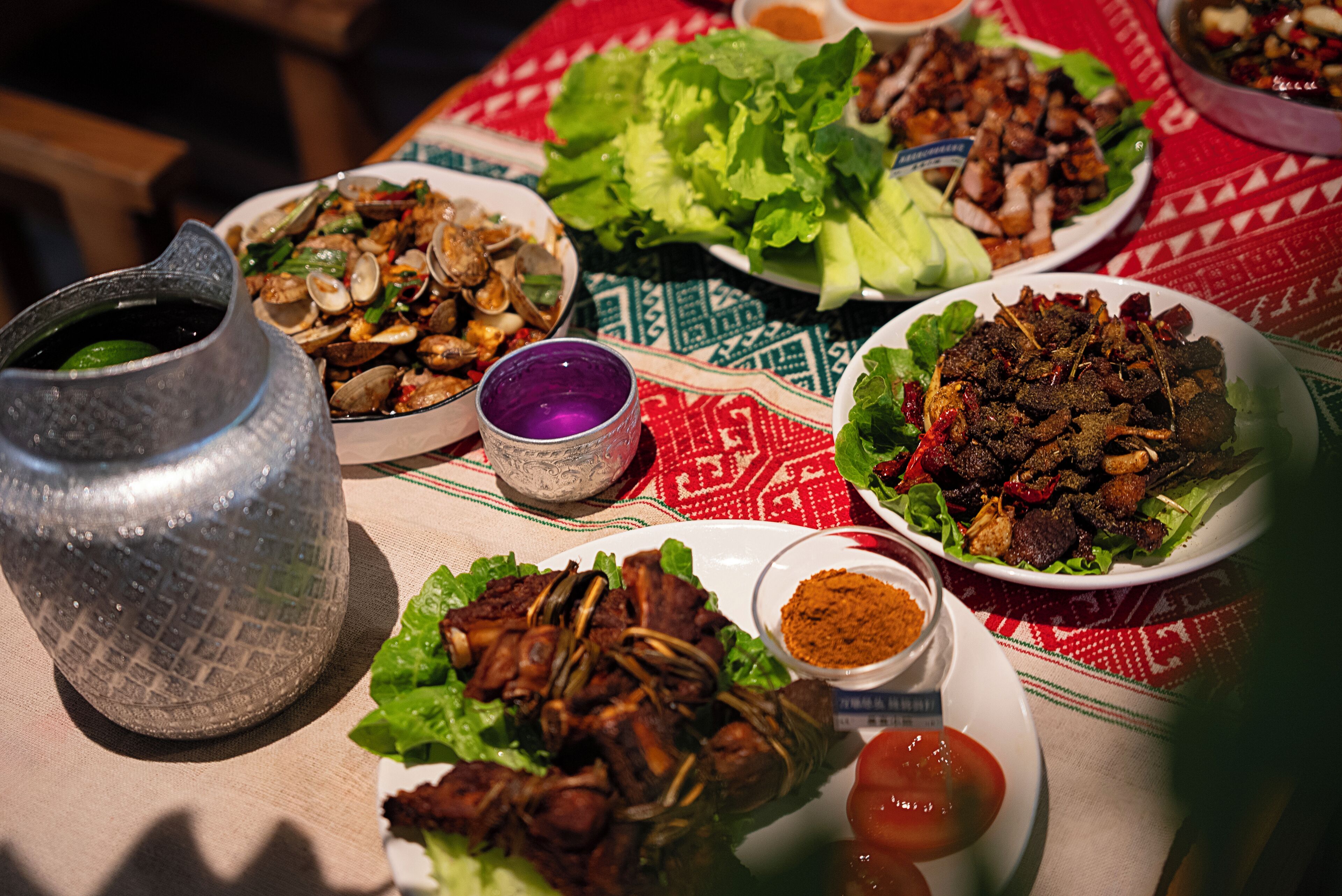 A table with various dishes, including seafood and meat, and condiments.