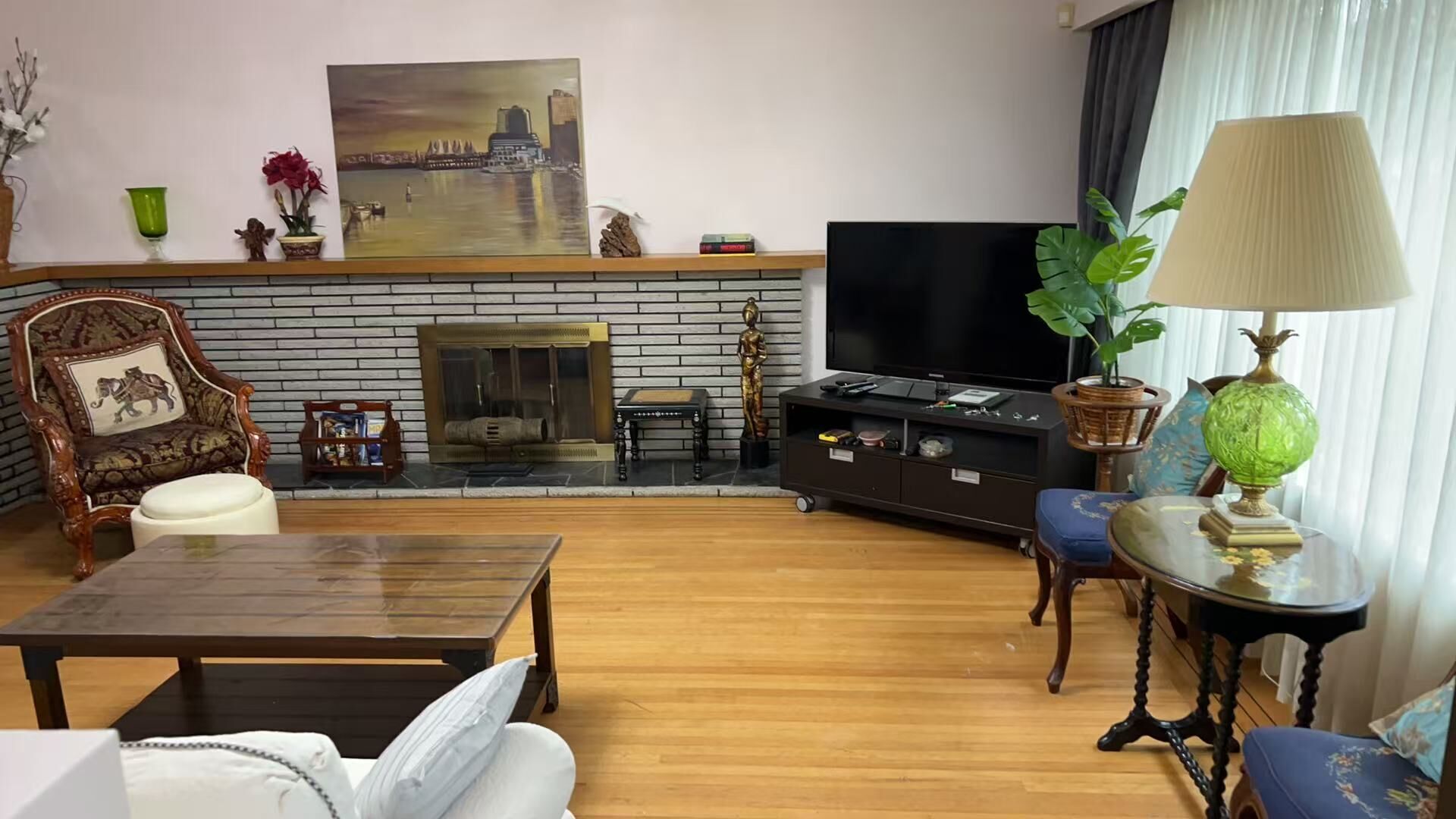 A living room with a fireplace, a television, a sofa, a coffee table, and decorative items.