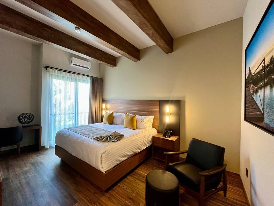A hotel room with a large bed, bedside tables, a desk, and a chair.