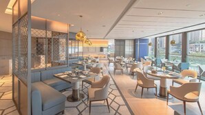 A modern restaurant with a mix of seating options including tables and a sofa area. - Jinke Grand Hotel Chongqing (Chongqing)