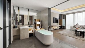 A modern bathroom with a freestanding bathtub, a vanity with a mirror, and a large mirror above the sink. - Jinke Grand Hotel Chongqing (Chongqing)