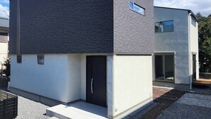 Ein modernes, zweistöckiges Gebäude mit flachem Dach und einer dunkelgrauen Fassade.