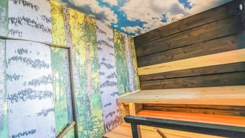 A room with a sloped ceiling, wooden beams, and a mural of a forest.