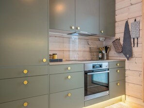 A modern kitchen with a built-in oven and a stainless steel range hood. - Villa rantakoivikko by Interhome (Karvia)