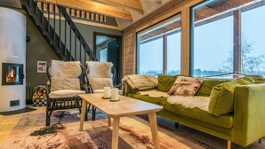 Una sala de estar acogedora con un sofá verde, una mesa de centro de madera y una chimenea.