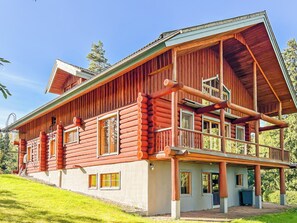Une cabane en rondins dotée d’un balcon et d’une mezzanine à l’étage.