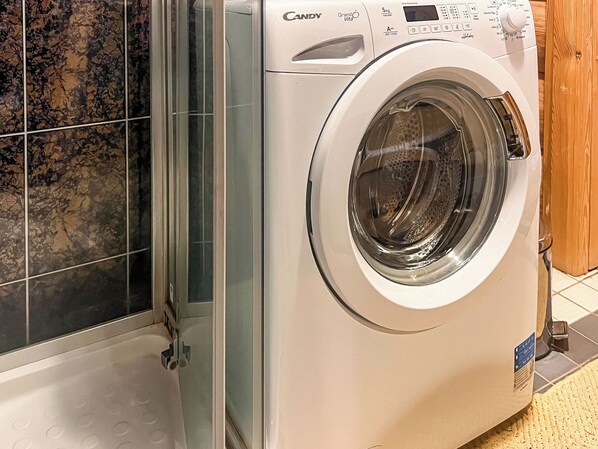 Un lave-linge Candy Grand Vita à chargement frontal, doté d’un écran numérique, d’un panneau de commande et d’une porte transparente.