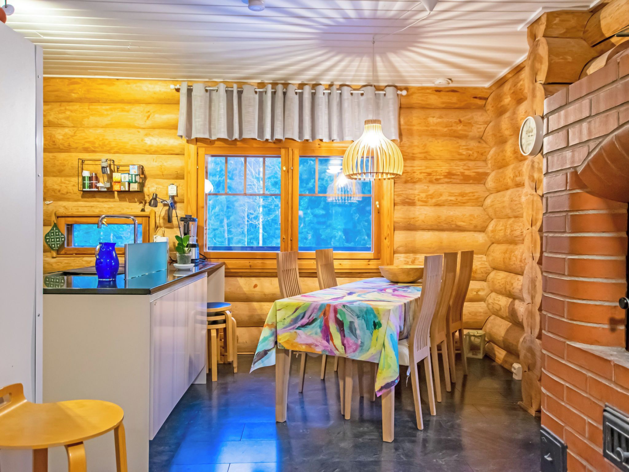 Ein gemütliches Blockhaus-Interieur mit Küche, Essbereich und einem großen Fenster.