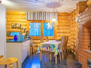 A cozy log cabin interior with a kitchen, dining area, and a large window. - Kiviranta by Interhome (Lahti)