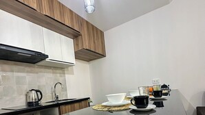 Una cocina moderna con armarios de madera, encimera negra y zona de café.