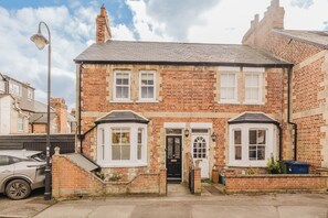 A two-story brick house with a black front door, white-framed windows, and a small front garden. - Stunning 3 Bedroom Oxford Retreat (Oxford)