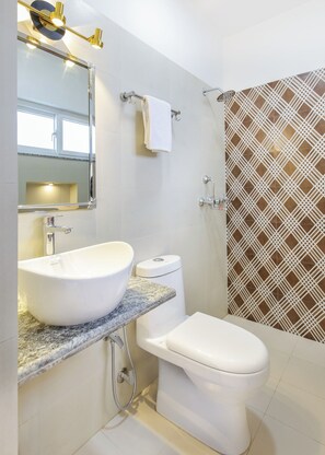 Een douche, handdoeken, zeep, toiletpapier