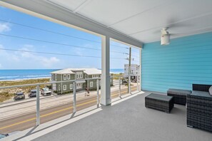 Enjoy the ocean view from this balcony with a sofa and table.