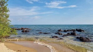 A beach with clear water, rocks, and a clear sky. - Palmeraiebeach Resort Rayong (Klaeng)