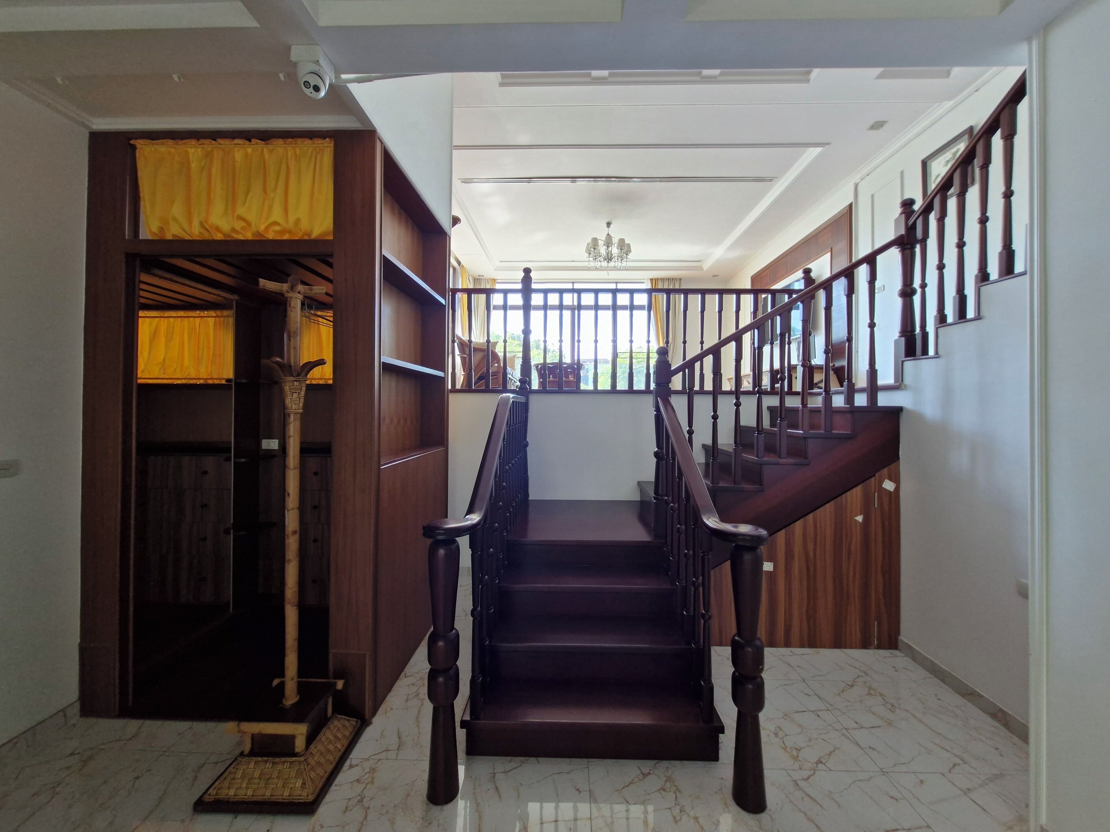 A staircase with wooden railings and a handrail, leading to an upper floor.