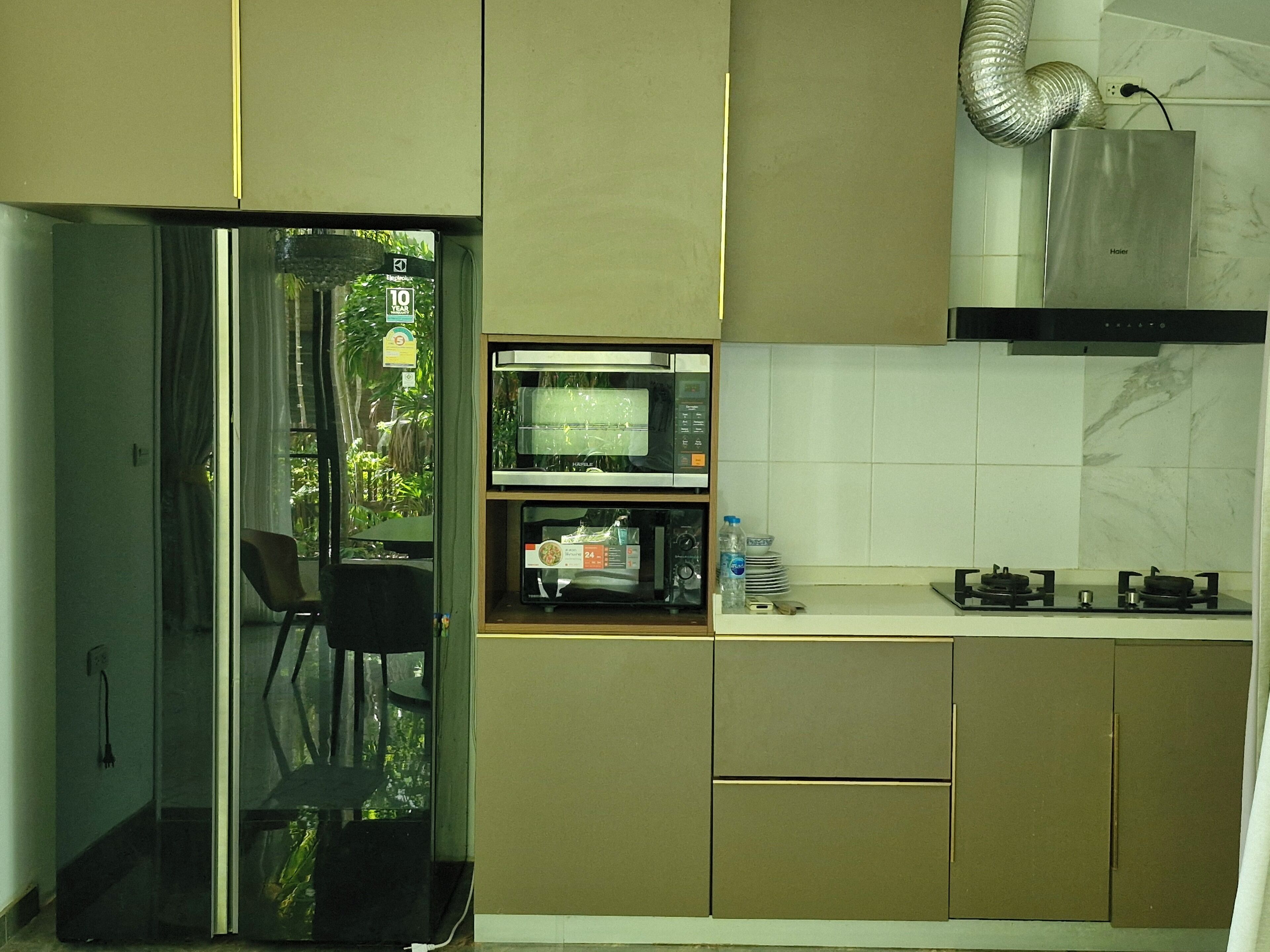 A modern kitchen with a microwave, stove, and a water dispenser.