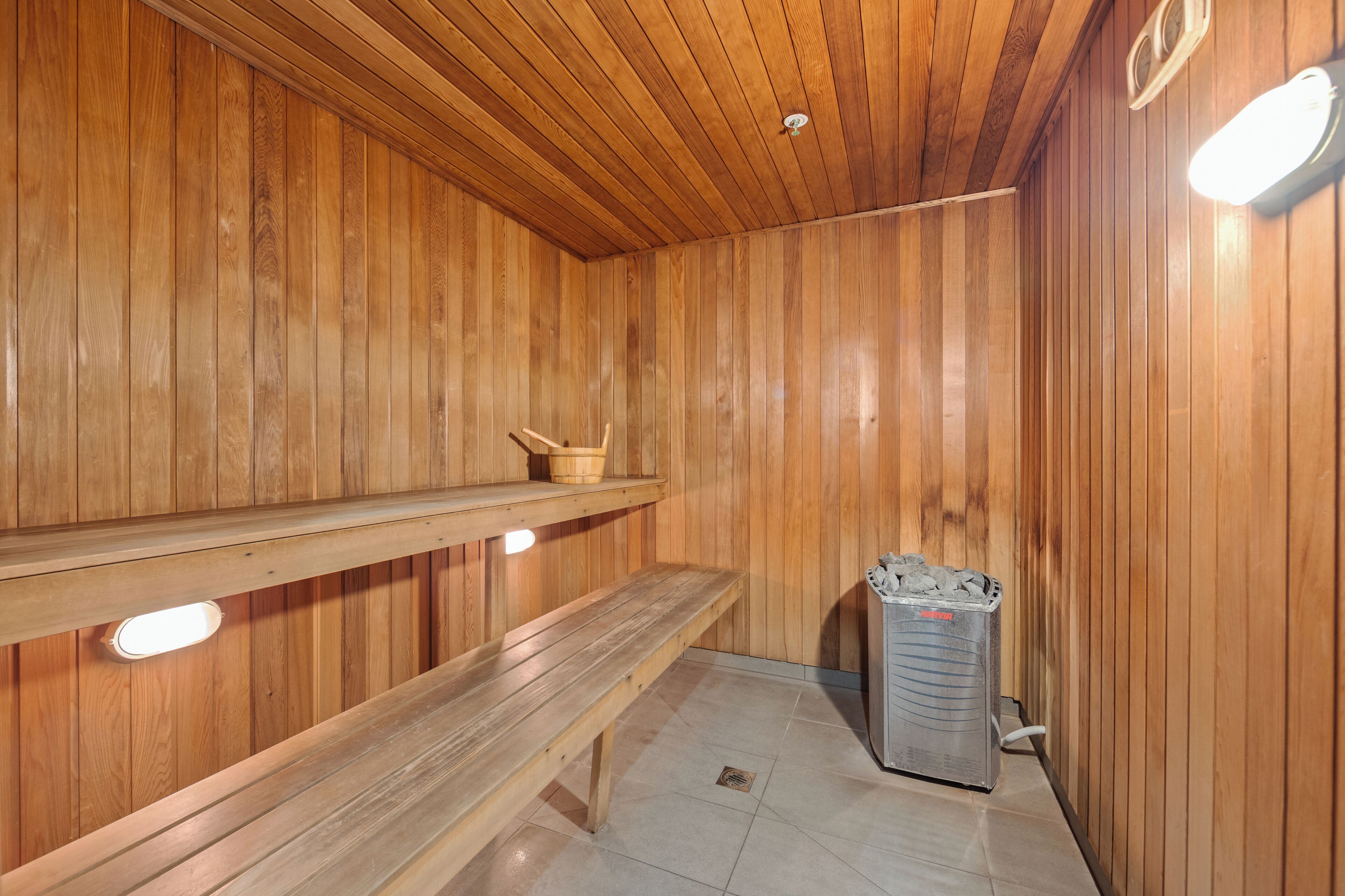 A wooden sauna with benches and a heater.