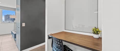 Un espacio de oficina moderno con una pared gris oscuro, un escritorio de madera y una silla azul perforada.